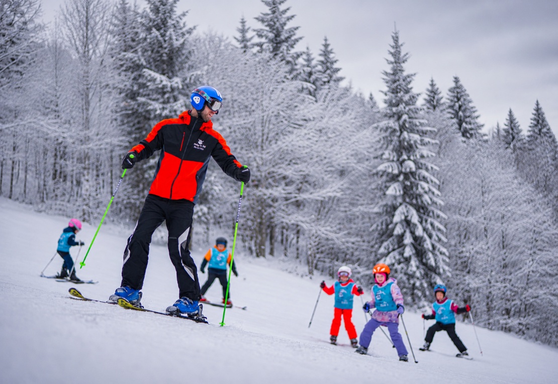 An instructor leads children during Saturday ski lessons